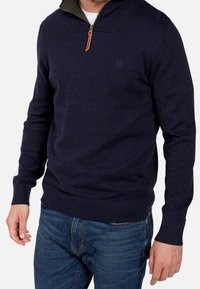 Marinblå zip-up tröja med ribbade kragar, kontrasterande grön innerkrage och en läderdragkedja; figursydd design och ribbade ärmslut.