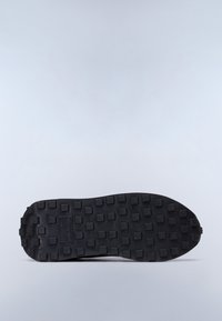 Schwarze Sportschuhsohle mit strukturierter Oberfläche und quadratischen Erhebungen für Grip und Stabilität; matte Oberfläche ohne sichtbare Markenkennzeichnung.