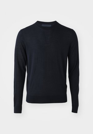 Tamno plava dugačka majica s dugim rukavima od finog, laganog materijala. Ima okrugli izrez i rebraste manžete i donji rub.