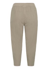 Beżowe spodnie z elastycznym pasem, zwężanymi nogawkami i widocznymi szwami, pokazane od tyłu na białym tle.