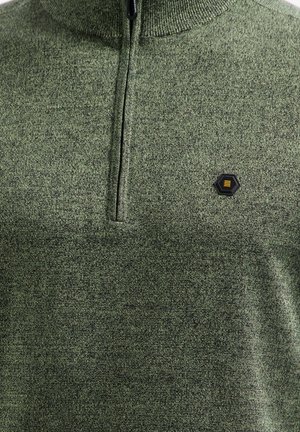 Diepgroene trui gemaakt van textiel met een gestructureerde stof, voorzien van een hoge kraag en een ritssluiting. Opvallend zwart hexagonaal logo op de borst.