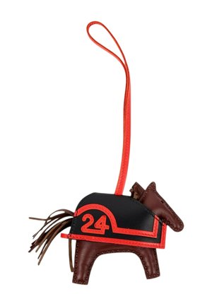 Charm pour sac en cuir marron en forme de cheval avec selle noire, bordure rouge, numéro 24 et boucle de suspension rouge.