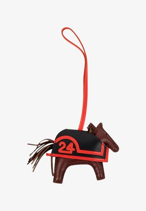 Charm pour sac en cuir marron en forme de cheval avec selle noire, bordure rouge, numéro 24 et boucle de suspension rouge.