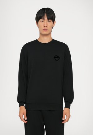 Zwarte sweatshirt van zacht materiaal, met een ronde halslijn, lange mouwen en een gestructureerd zwart logo op de linkerborst.