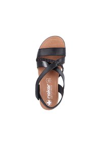 Svart lädersandal med korsande remmar, texturerad innersula och vadderad fotbädd. Har en blank yta och en platt sula.