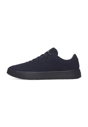 Niedrig profilierter schwarzer Sneaker mit Schnürdesign, strukturierter Sohle und glattem Stoffobermaterial, von links auf weißem Hintergrund gezeigt.
