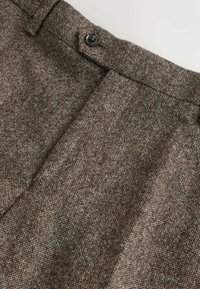 Brown tweed fabric with a textured, multi-tonal pattern. Features a standard waistband with a button closure and sharp, pressed creases.