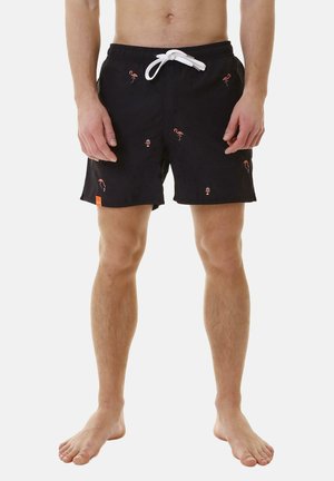 Costumi da bagno neri con vita regolabile tramite cordino, caratterizzati da ricami colorati di fenicotteri e gnomi, tessuto leggero e taglio sopra il ginocchio.