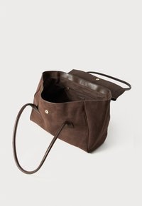 Sac fourre-tout en suède marron avec anses en cuir, ouvert montrant un intérieur spacieux et une poche zippée, texture lisse et détail de logo subtil.