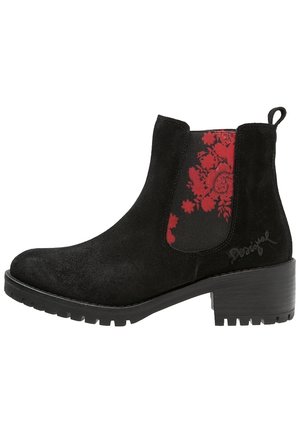 Bottine en daim noir avec talon bloc, semelle crantée, languette de tirage et panneau latéral élastique à motif floral rouge.