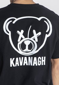 Černé bavlněné tričko s bílým potiskem grafiky medvědího obličeje a slovem "KAVANAGH" níže. Jednoduchý design s jasnými liniemi.