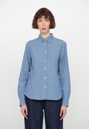 Light blue, long-sleeved shirt made of denim fabric. Features a classic collar and front button closure with pearl-like buttons.