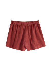 Röda, texturerade bomullsshorts med resårmidja och lös passform. Fållarna slutar ovanför benet och har en slät yta och en avslappnad design.