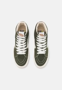 Sneakers high-top verde in suede con lacci bianchi, fodera crema, logo iconico Vans e dettagli di cucitura a contrasto.