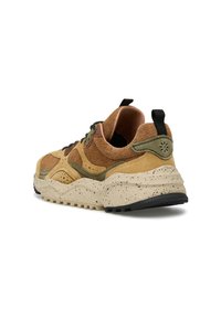 Sneaker in suede marrone e tan con dettagli verde oliva, suola beige maculata, linguette nere e suola nera, vista laterale posteriore su sfondo bianco.