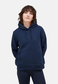Mörkblå hoodie i mjukt tyg, med en kenguruficka, ribbade ärmslut och en liten logotyp på bröstet.