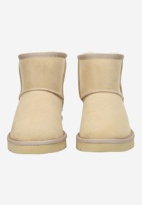 Botas de tobillo de ante color beige con puntera redondeada, detalles cosidos y un interior mullido, que cuentan con una suela de goma plana para un buen agarre y durabilidad.