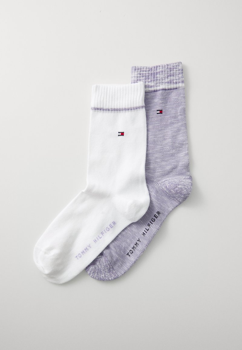 Zwei Paar Socken: eine weiße mit geripptem Bündchen und Logo, und eine lila mit einer gesprenkelten Textur, beide mit dem Markennamen "Tommy Hilfiger".