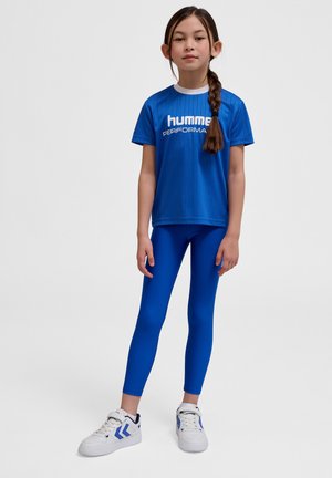 Blå atletisk t-shirt med hvid skrift "HUMMEL PERFORMANCE," parret med blå leggings og hvide sneakers med blå accenter.