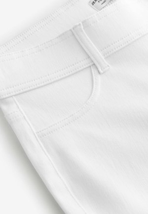 Jeans di denim bianco con una texture liscia, dotati di una tasca anteriore, cuciture a punto e una vita con chiusura a bottone.