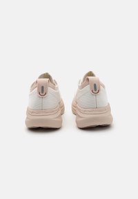 Zapatillas deportivas blancas y beige con una parte superior de tejido texturizado, suela de goma y una lengüeta en el talón. Logo de ASICS grabado en el lateral.