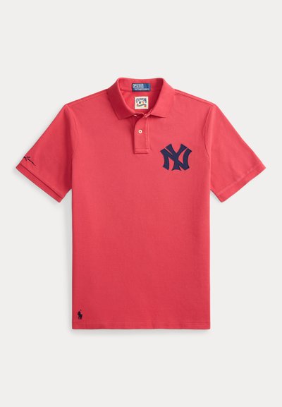 Κόκκινο polo Ralph Lauren με ναυτικό μπλε λογότυπο New York Yankees στο αριστερό στήθος και μαύρο κεντητό λογότυπο αλόγου κοντά στο τελείωμα.