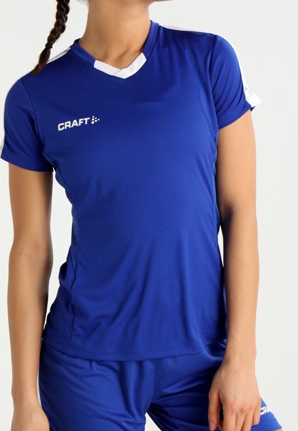 Blå atletisk t-shirt med v-hals, korte ærmer og hvide detaljer. Har et logo på brystet og er lavet af åndbart, let materiale.