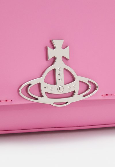 Borsa in pelle verniciata rosa con un logo metallico a forma di corona, con accenti a croce e circolari, che mette in risalto la sua superficie lucida e il design audace.