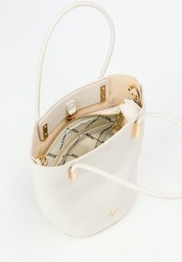 Borsa a secchiello bianca in pelle con finitura testurizzata, dettagli in metallo dorato e un interno cucito che presenta un comparto con zip.
