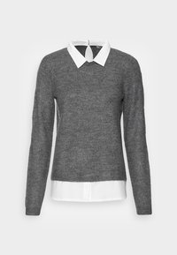 Pull gris à manches longues sur une chemise blanche à col. Le pull a un décolleté rond et une ouverture en forme de clé au dos.