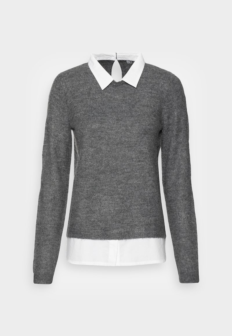 Pull gris à manches longues sur une chemise blanche à col. Le pull a un décolleté rond et une ouverture en forme de clé au dos.