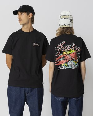 Zwarte katoenen T-shirts met een klein borstlogo en een levendige kreeftenafbeelding op de achterkant, gecombineerd met spijkerbroeken en accessoires.