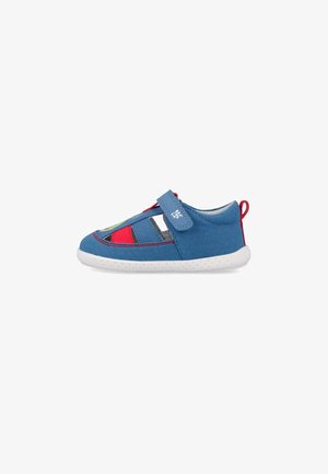Sandalia para niño pequeño en azul y rojo con suela blanca, tira de velcro, lados abiertos y un lazo rojo en el talón.