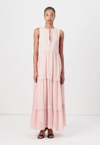 Abito maxi senza maniche di colore rosa realizzato in tessuto leggero, con pieghe verticali, chiusura con laccetto al collo e orlo a balze a strati.