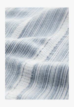 Textil cu dungi albe și bleumarin deschis, având o textură țesută și modele subtile, expus într-o poziție drapată.