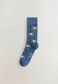 Chaussettes bleues avec des motifs de personnages de dessin animé tenant des boissons, dotées d'un bord côtelé, d'une texture lisse et d'un texte imprimé disant "COMMENT TU BOIS ?"