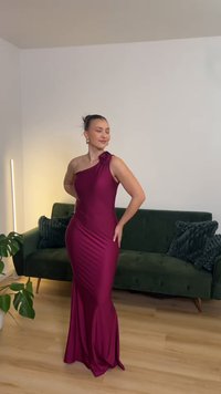 Garš, piegulošs vakarkleita dziļā tumši sarkanā krāsā. Vienas pleca dizains ar ziedu akcentu. Gluda tekstūra, drapēti elementi un zvana formas apakšmala.