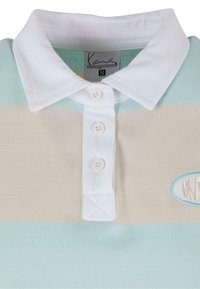 Polo shirt rayé bleu clair, beige et blanc avec un col blanc, patte de boutonnage à cinq boutons et logo brodé. Matière en mélange de coton.