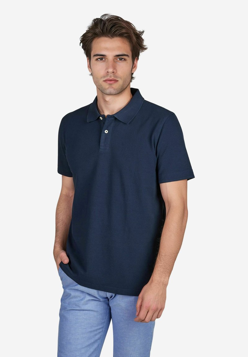 Navy polo shirt van een zachte katoenmix met een kraag, korte mouwen en drie knopen bij de nek. Eenvoudig ontwerp zonder patronen of accenten.