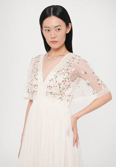 Κεντητό διαφανές φορεμα με λουλουδένιο σχέδιο, V-λαιμόκοψη, κοντά μανίκια και υφή υφάσματος. Διαθέτει δαντέλα και πλισέ φούστα.