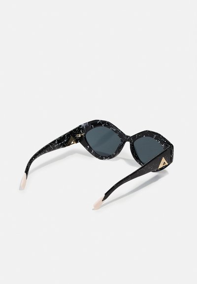 Black sunglasses with a marbled pattern, grey lenses, and cream-colored tips. Gold triangular accents on the outer frame. Angular design.