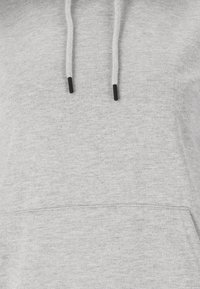 Grijze hoodie van zachte stof, met een kangoeroezak, trekkoorden met zwarte tips en een gestructureerde afwerking.