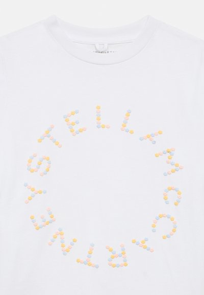 Λευκό βαμβακερό t-shirt με την επιγραφή "STELLA McCARTNEY" σε πολύχρωμα, υφασμένα γράμματα σε σχήμα εξαγωνικού πλέγματος, διατεταγμένα σε κυκλικό μοτίβο.