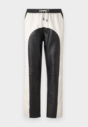 Black and cream colored pants featuring a relaxed fit, elastic waistband with drawstring, and a mix of leather and fabric materials.