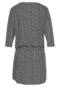 Schwarzes Kleid mit dreiviertel Ärmel, das ein weißes und hellgraues geometrisches Muster aufweist. Hat eine lockere Passform und einen elastischen Bund.