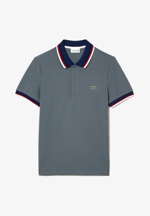 Polo gris avec un col et des poignets rayés bleu marine, rouge et blanc. Comprend trois boutons et un logo Lacoste vert sur la poitrine.