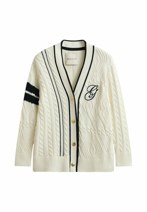 Cremefarbener Strickcardigan mit Zopfmuster, schwarzen Streifen, goldenen Knöpfen und einem gestickten "G" auf der Brust, mit tiefem V-Ausschnitt sowie gerippten Bündchen und Saum.