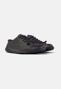 Scarpe in pelle grigio scuro con punta rotonda, design allacciato e look minimalista. Presentano una suola flessibile con dettagli di cucitura sottili.