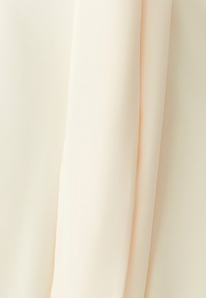 Helebeežikas kangas langeb graatsiliselt, omades siledat tekstuuri ja veidi läbipaistvat kvaliteeti. Materjal tundub pehme ja voolav.