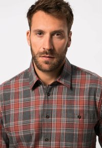 Skjorte i ternet mønster lavet af stof i grå, rød og hvid; har en knap-ned krave og to brystlommer med knapper.